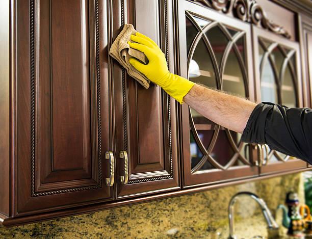 Man Cleaning Wood Kitchen Cabinets